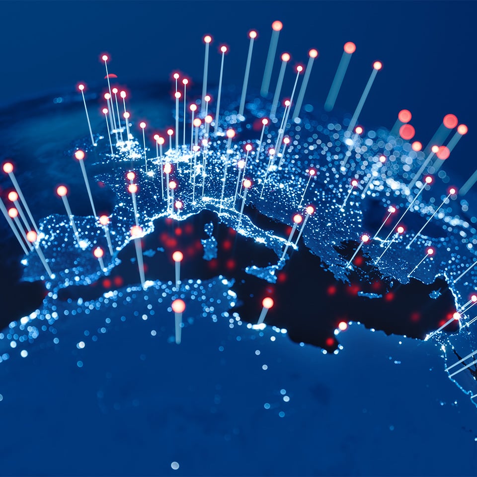 Closeup of a globe with lighted pins above various cities