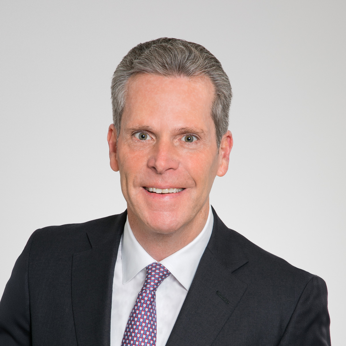 Professional headshot of Brian McDonagh with gray background.