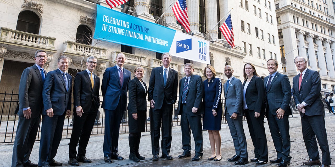  Silver Lakeleadership standing in front of the New York Stock Exchange with a banner celebrating Silver Lake's 100th anniversary in the background.